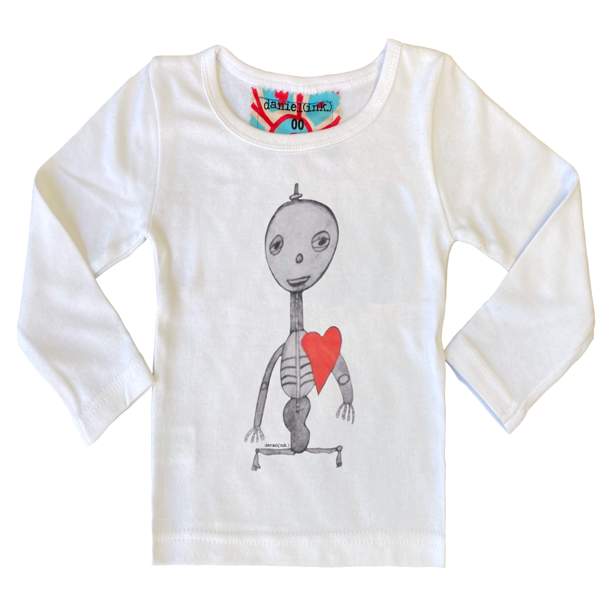 White long sleeve babies’ shirt featuring a hand drawn sketch of a skeleton with a red heart. The shirt has a red, white, and blue fabric label on the back of the neck.