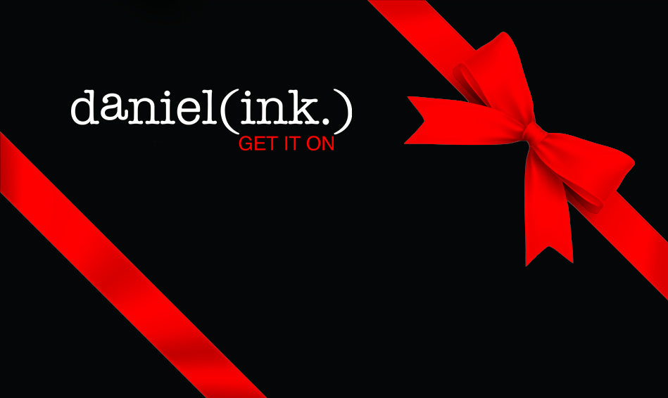 Black card with red ribbon wrapped around it and a red bow in the top right corner. The daniel(ink.) logo in white and red is in the top left corner of the card.