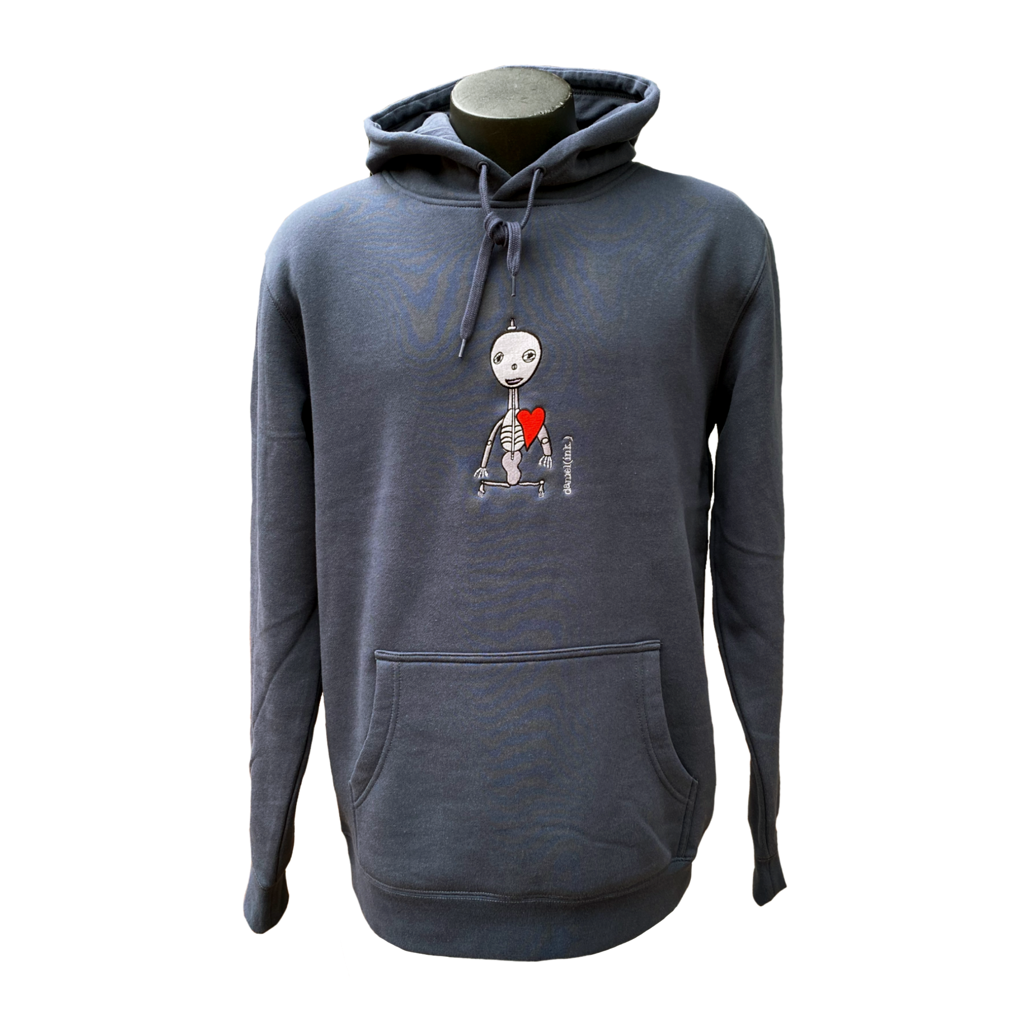 Unisex blue hoodie featuring an embroidered image of a silver skeleton with a red heart. The name daniel(ink.) is embroidered in silver thread next to the skeleton.