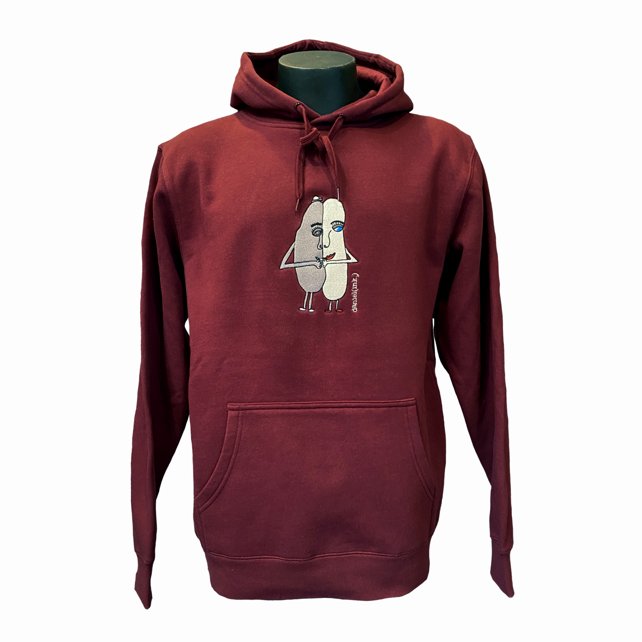 Unisex burgundy hoodie featuring an embroidered image of two oval-shaped humanoid figures merged side by side and holding hands in silver. The name daniel(ink.) is embroidered in silver thread to the right of the figures.